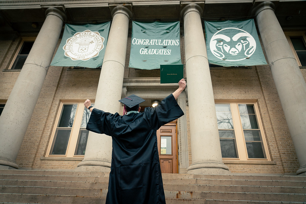 Graduate celebrating on the steps of the Administration Building on CSU's campus
