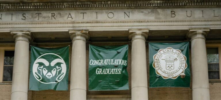 Colorado State University Administration building with graduation banners reading, "Congratulations Graduates!"