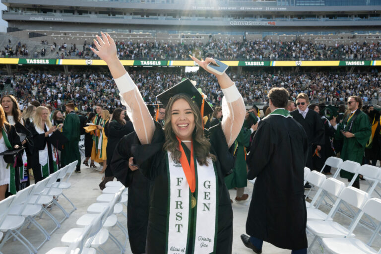CSU graduate raises her arms in celebration at University-wide Commencement in 2025