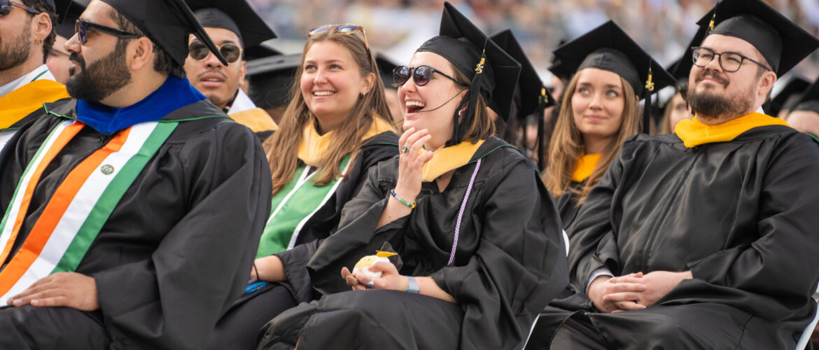 Graduating students sit on the floor of Canvas Stadium during University-wide Commencement 2025.