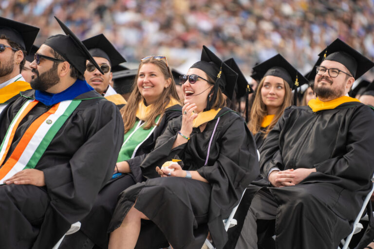 Graduating students sit on the floor of Canvas Stadium during University-wide Commencement 2025.